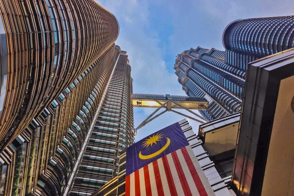 Malaysian flag flying with the Petronas Twin Towers in the background