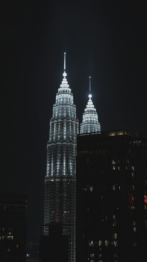 Tall vertical view of Petronas Towers at night